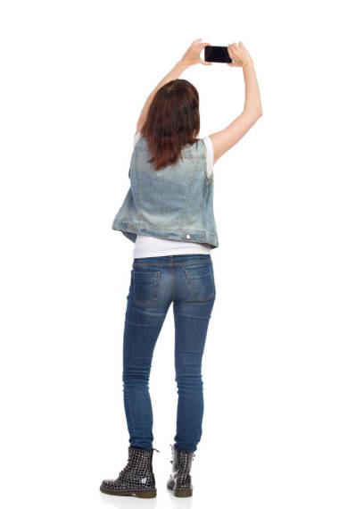 女人正在用手機(jī)拍照。后視圖