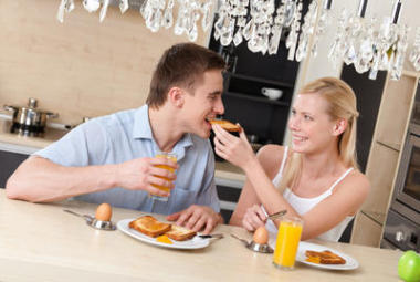 女人用的早餐喂他丈夫在廚房