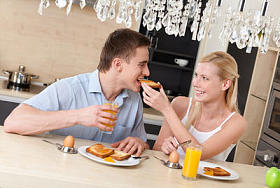 女人用的早餐喂他丈夫在厨房