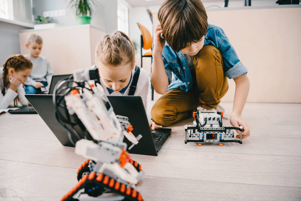 集中的孩子坐在地板上机械类, 茎教育概念 集中的孩子坐在地板上机械类, 茎教育概念