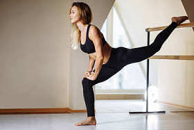 在健身课上舒展身体的女孩微笑和看镜子