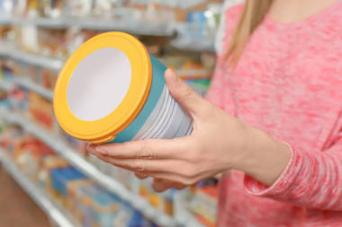 年輕婦女選擇在超級市場的嬰兒食品, 特寫