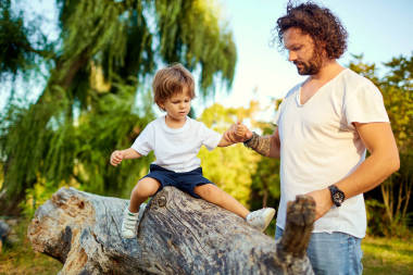 爸爸在公園里和兒子玩. 照片