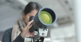 年轻女子通过望远镜观察