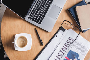 商務(wù)工作場所的高級視圖與筆記本電腦和報(bào)紙