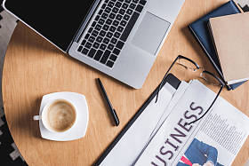 商务工作场所的高级视图与笔记本电脑和报纸