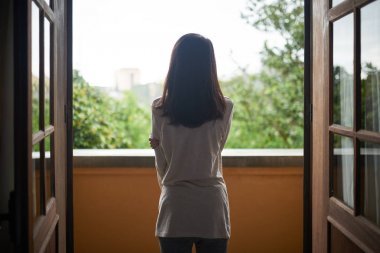 站在陽臺上欣賞風景的婦女后視圖