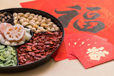 農(nóng)歷新年中國(guó)小吃托盤, 紅色包和中國(guó)書法單詞意味著運(yùn)氣