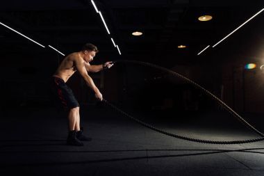 與戰(zhàn)斗健身的人鍛煉的繩索在健身房。訓(xùn)練演習(xí)在俱樂部安裝了身體。軀干