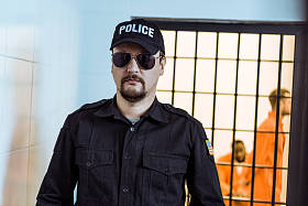 监狱看守站在牢房附近与多文化囚犯