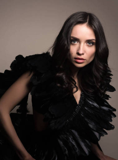 年輕美麗的女人在黑色的時(shí)尚肖像。羽毛連衣裙