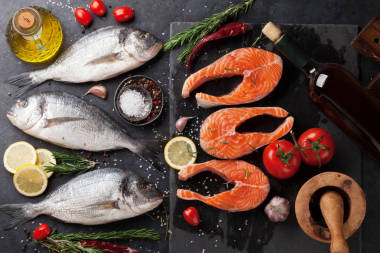 生鮭魚魚片和金魚魚與香料烹飪?cè)谇懈畎?。頂部視圖