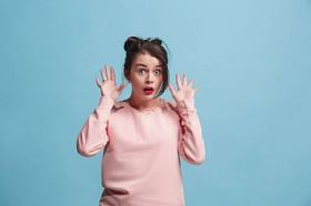 美丽的女人看着惊讶的蓝色孤立