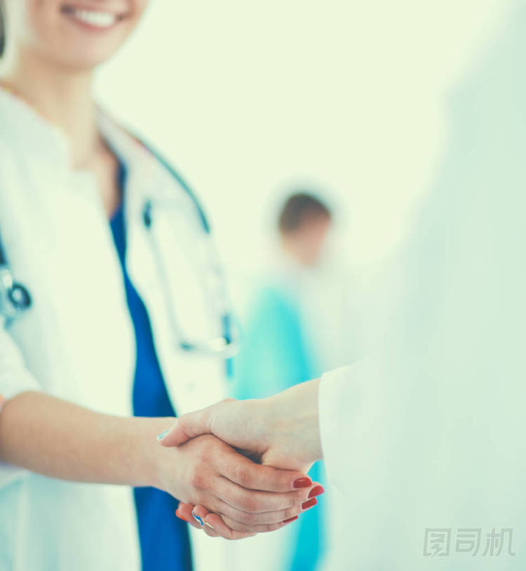 年輕的醫(yī)護(hù)人員握手站在醫(yī)院