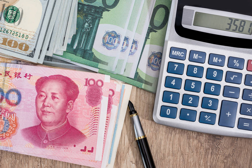 美元, 欧元, 人民币钞票, 桌上有计算器 美元, 欧元, 人民币钞票, 桌上有计算器