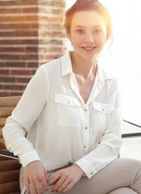 成功的年轻商业女人坐在办公桌前