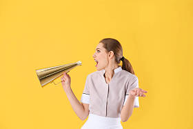 黄色背景扩音器的年轻女服务员