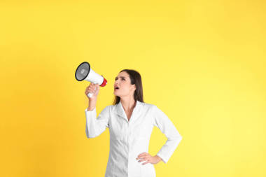 黃色背景擴音器女醫(yī)生