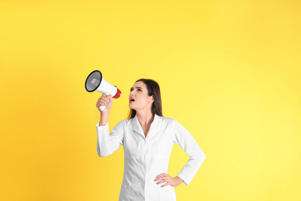 黄色背景扩音器女医生