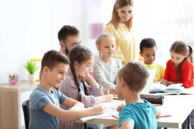 教師在學(xué)校課堂上幫助孩子做作