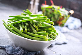 碗中的青豆和桌上曼戈尔德的新鲜叶子