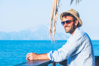 在海灘酒吧欣賞風(fēng)景的年輕英俊的人