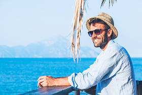 在海滩酒吧欣赏风景的年轻英俊的人