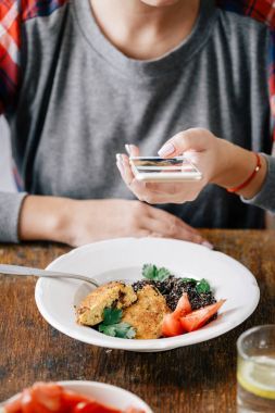 婦女從燕麥和李子圖片黑奎奴亞和肉餅, 健康素食概念