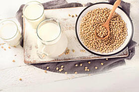 在木桌上的豆浆和大豆。素食和素食概念