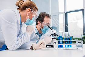 研究人员在白色大衣和医疗口罩一起使用试剂在实验室