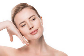 女性用干净的皮肤触碰自己的面孔在白色被隔绝了