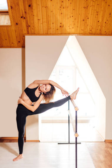 在健身課上舒展身體的女孩微笑和看鏡子