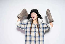 愉快的笑俄国女孩在温暖的帽子举行冬天毛毡靴