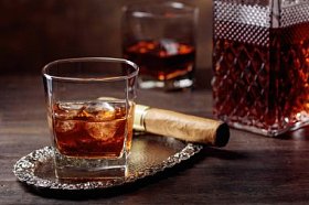 旧木桌上的威士忌和雪茄杯