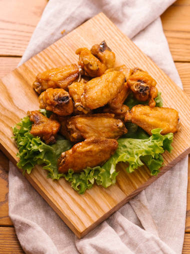 木制切板上配生菜的炸鸡翅