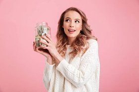 漂亮的年轻女子拿着罐子的钱