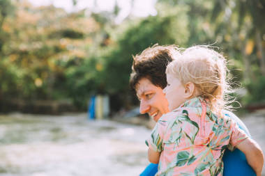 快乐的父亲抱着可爱的小女儿在热带海滩