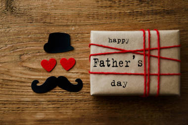 手工禮品盒綁在舊木桌上的紅色繩子與葡萄酒。快樂父親節(jié)賀卡