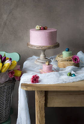 复活节餐桌装饰, 美味的自制蛋糕与春天的花朵和彩绘鸡蛋在假日餐桌上。篮子新鲜安置接近复活节