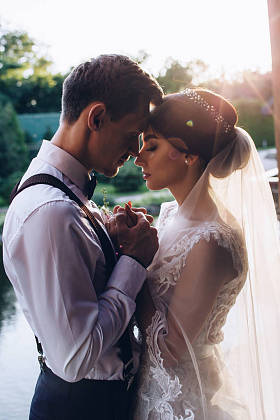 晚上的新婚夫妇在池塘散步.图片