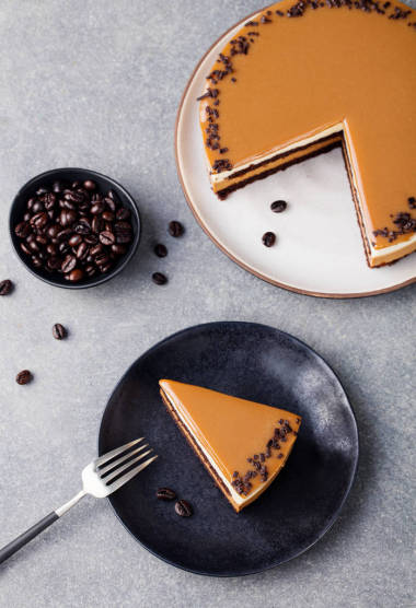 焦糖蛋糕, 慕斯甜點在盤子里。灰色的石頭背景。頂部視圖