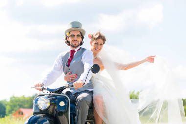 一对新婚夫妇，驾驶摩托车穿婚纱和西装