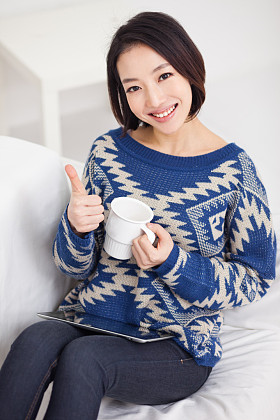 年轻的亚裔女子使用 pc 的键盘和显示的拇指