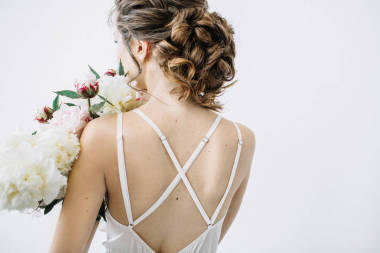 年輕美麗的婦女與牡丹花花束的后面