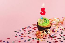 第五生日蛋糕与蜡烛和洒图片