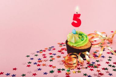 第五生日蛋糕与蜡烛和洒图片