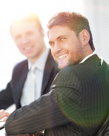 成功的商人和他的同事坐在一張桌子后面