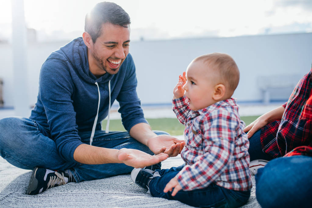 快乐家庭的妈妈和爸爸抱着一个婴儿在家里玩 快乐家庭的妈妈和爸爸抱着一个婴儿在家里玩