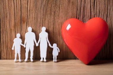 一個(gè)家庭的特寫除了紅色的心臟形狀外牽手