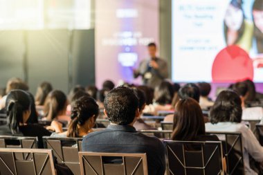 觀眾在會議廳或研討會會議上的后視圖在舞臺、商業(yè)和教育概念的前面有演講者